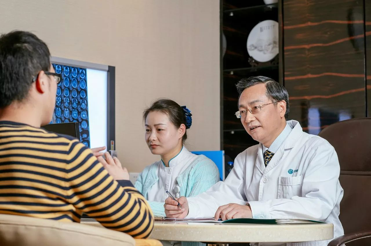 Professor Donglei Song consulting with a patient and clinical colleague